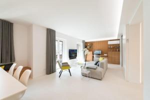 a white living room with a couch and chairs at luxuriöse Ferienwohnung in Mittenwald für Genießer in Mittenwald