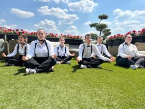 um grupo de pessoas sentadas na grama em meditação em Best Western Plus Thionville Centre em Thionville