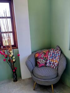 a chair in a corner with a vase with flowers at Desired View in Choiseul
