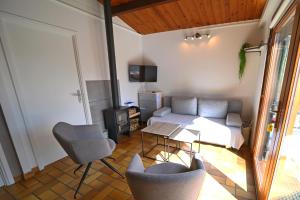 a living room with a couch and a table and chairs at Les Trois Feuilles in Petit Mesnil