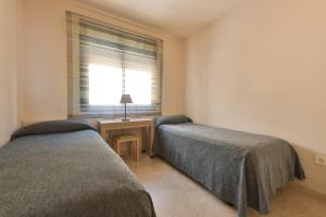 1 Schlafzimmer mit 2 Betten neben einem Fenster in der Unterkunft Apartamento con vistas al mar y parking incluido in Torrox Costa