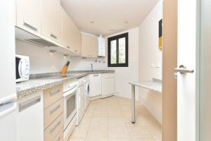 eine Küche mit weißen Schränken und einem Fenster in der Unterkunft Apartamento con vistas al mar y parking incluido in Torrox Costa