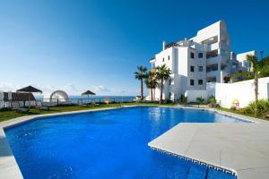 ein großes Schwimmbad vor einem Gebäude in der Unterkunft Apartamento con vistas al mar y parking incluido in Torrox Costa