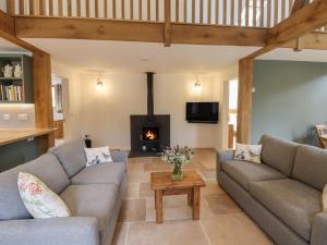 a living room with two couches and a fireplace at Swallows Lodge in Edenbridge