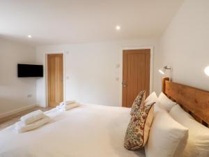 a bedroom with a large white bed with two pillows at Swallows Lodge in Edenbridge
