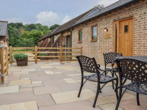 a patio with chairs and a table and a building at Swallows Lodge in Edenbridge