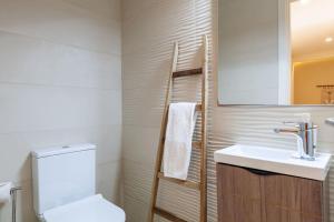 a bathroom with a white toilet and a sink at Apartamento Lírio - Minho's Guest in Braga