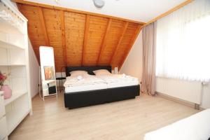 um quarto com uma cama e um tecto de madeira em Casa Cara em Baiersbronn