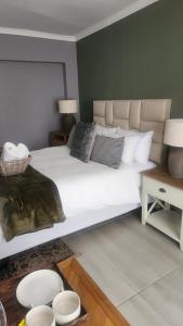 a bedroom with a large white bed with pillows at Bella on St James in Johannesburg +1 photo