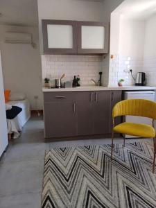 una cucina con sedia gialla e lavandino di סטודיו עידן a Tel Aviv