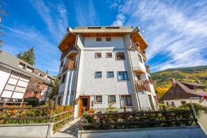a large white building with a staircase in front of it at Il Rododendro City Center - Happy Rentals in Bardonecchia