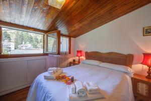 a bedroom with a large bed with towels on it at Il Rododendro City Center - Happy Rentals in Bardonecchia