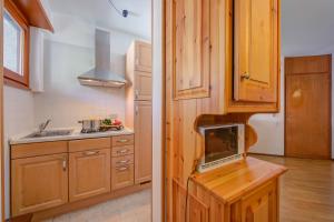 a kitchen with wooden cabinets and a laptop on a counter at Il Rododendro City Center - Happy Rentals in Bardonecchia