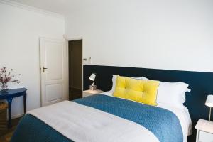 a bedroom with a blue and white bed with yellow pillows at Cherry Blossom - Backup Power Inverter in Ceres