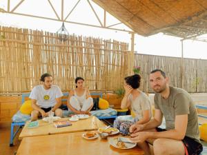a group of people sitting around a table at Jaisalmer Hostel Crowd in Jaisalmer