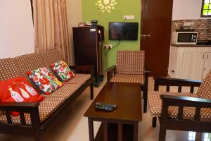 a living room with a couch and chairs and a table at Mahabs homestay Villa in Mahabalipuram