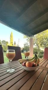 a plate of fruit on a table with a glass of wine at Lonelia's Family Homes in Lefkímmi