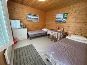 een kamer met een bed en een tafel in een hut bij Porotila Toini Sanila in Sevettijärvi