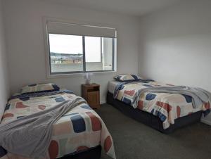a bedroom with two beds and a window at Modern & Relaxed Apartment, Great Views @Wright in Weston Creek
