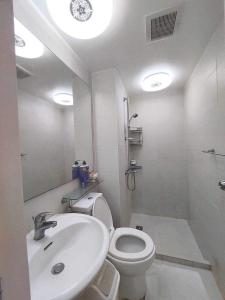 a bathroom with a white toilet and a sink at Velvet Waves in Manila