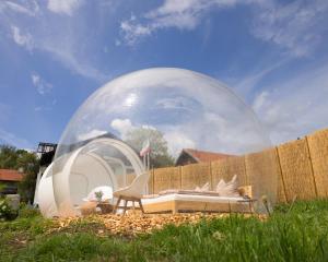 ein Blasenzelt mit einem Bett und einem Stuhl im Hof in der Unterkunft Bubble Tent Füssen im Allgäu in Füssen