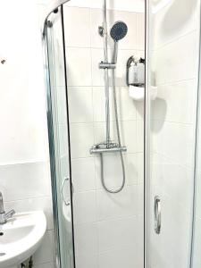 a shower with a glass door next to a sink at Humber Maisonette Airy, Modern & Chic! in Goole