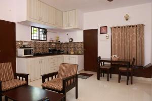 een keuken en eetkamer met een tafel en stoelen bij Mahabs homestay Villa in Mahabalipuram