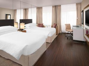エディンバラにあるシェラトン グランド ホテル＆スパのベッド2台とテレビが備わるホテルルームです。