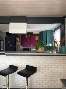 a bar with two black stools in a kitchen at LA DRYADE 