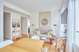 a living room with a couch and a table at Rent a Room apartments - Degas in Paris