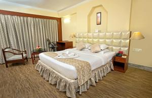 a large bedroom with a large bed with a large headboard at Hotel Rajmahal in Guwahati