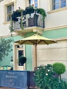 Villa Marengo Guest House في سبينيتّا: جلسه مظله امام مبنى