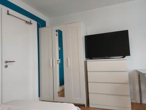 a bedroom with a bed and a flat screen tv at Rooftop Apartments - Doppelzimmer in Gemeinschaftsunterkunft (Weinberg R2) in Ulm
