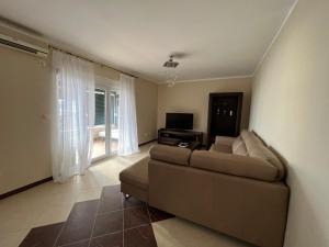 a living room with a couch and a television at Przno apartment in Budva