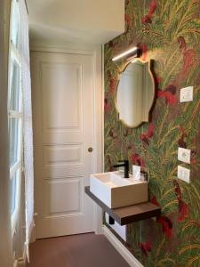 łazienka z umywalką i tapetą kwiatową w obiekcie Villa Marengo Guest House w mieście Spinetta