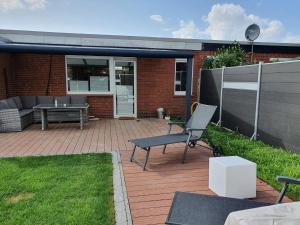une terrasse avec un canapé, une table et un banc dans l'établissement Ferienhaus-Wiesenpieper, à Dornumersiel