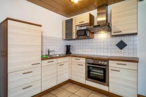 uma cozinha com armários de madeira e um forno com placa de fogão em Drei-mädelhaus Ambs Wohnung 2 