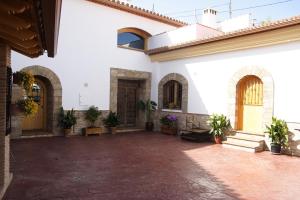 een binnenplaats van een wit gebouw met potplanten bij Cuevas las Chimeneas in Guadix