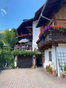 a house with flowers on the balconies of it at Blusnerhof in Virgen