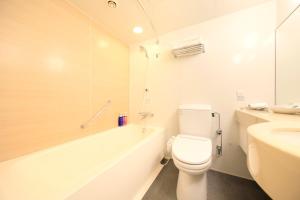 La salle de bains est pourvue de toilettes, d'une baignoire et d'un lavabo. dans l'établissement Richmond Hotel Narita, à Narita