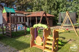 a playground with a slide and a swing set at Azyl in Dębki