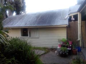 une maison avec un toit gris et une clôture dans l'établissement Sylvia Lodge A step back in time pet friendly Homestay, à Orbost