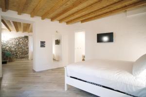 a white bedroom with a bed and a television at Casa Marinari in Scalea