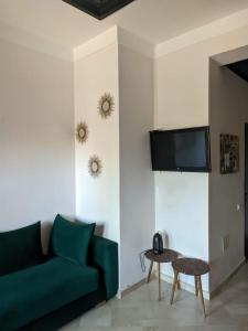 a living room with a green couch and a tv at Jannat azaytoun in Marrakesh