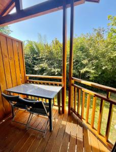 una mesa y una silla en un porche en Bel appartement cosy dans résidence avec piscine 5 minutes plage, en Messanges