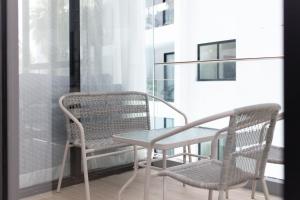 2 Stühle und ein Tisch auf dem Balkon in der Unterkunft 2bdr Apartment near Surin beach #302 in Ban Lum Fuang