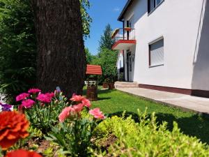 a garden with flowers in front of a tree at Rooms Lisičić in Kola&scaron;in