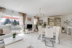 a white living room with a table and chairs at Magnifique 4 pers plage à pied in Fréjus