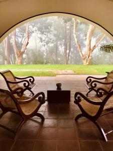 two benches and a table in front of a window at Dunwatta House in Kandy