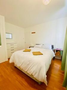 a bedroom with a white bed with two towels on it at Wonderful Apartment in London in The Hyde